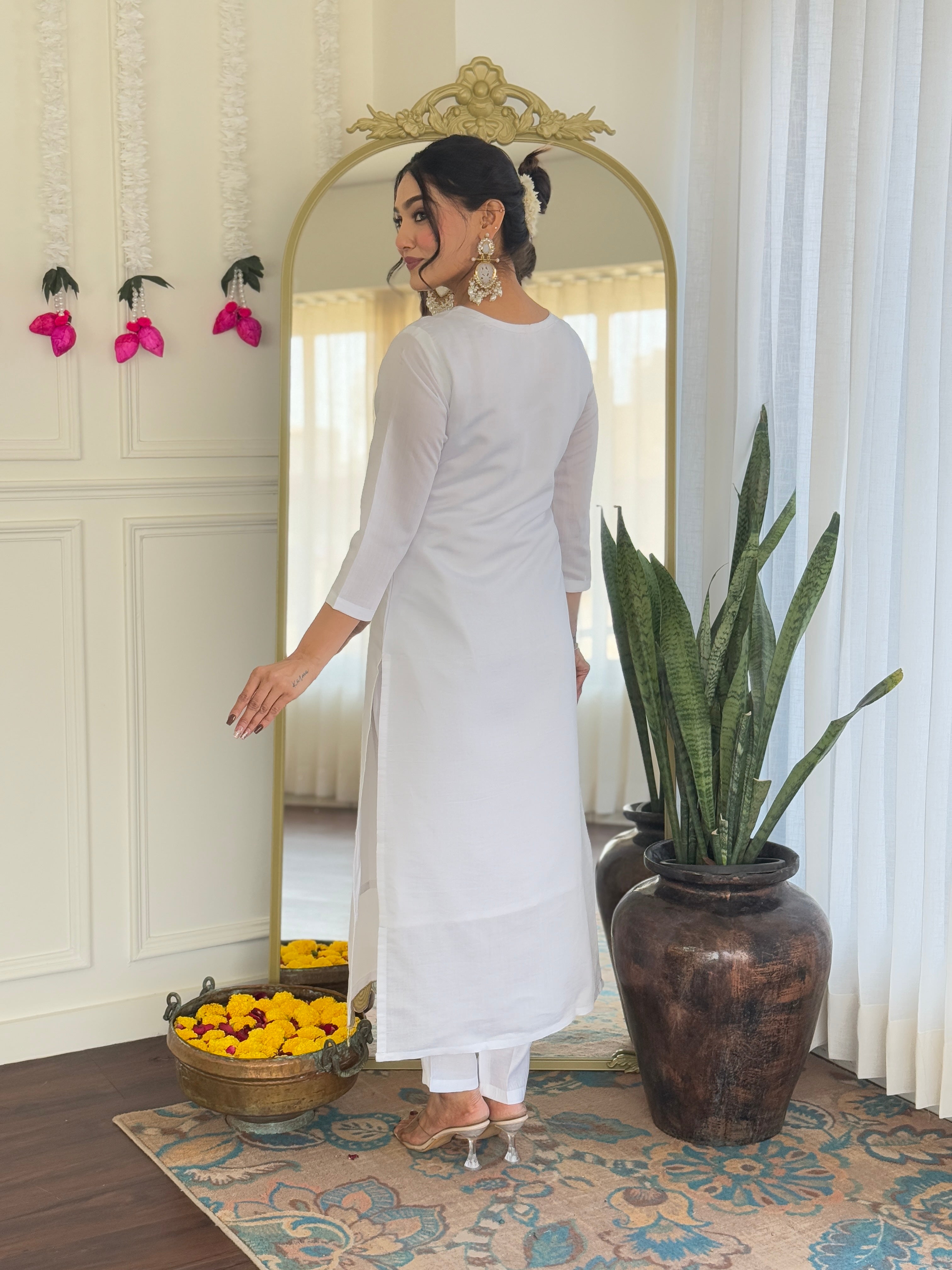 Rear view of the model's outfit, showing the classic silhouette of the white kurta and pants.