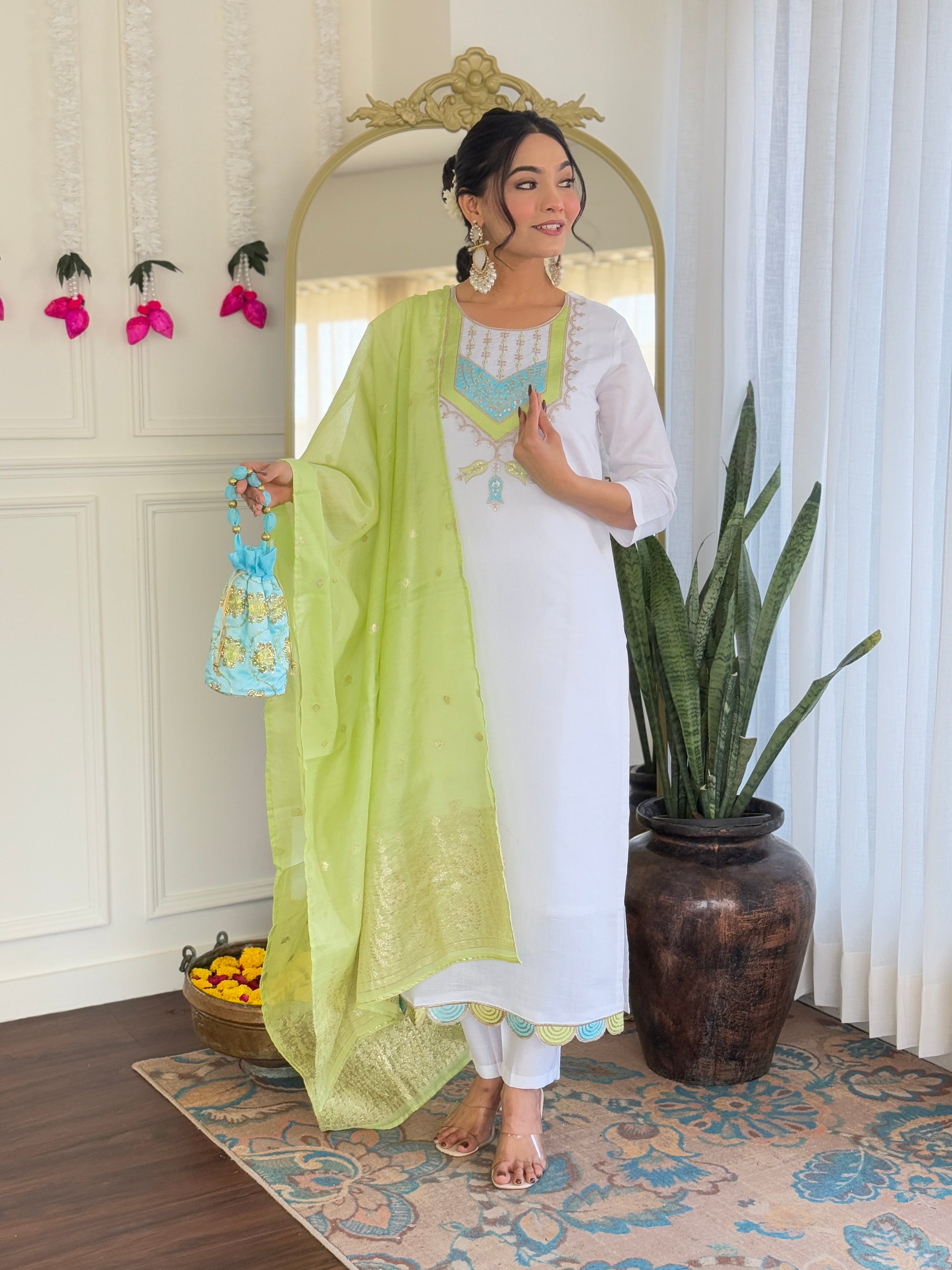 Model presenting the white Viscose Chanderi kurta set, holding the lime green dupatta and an embroidered potli bag.