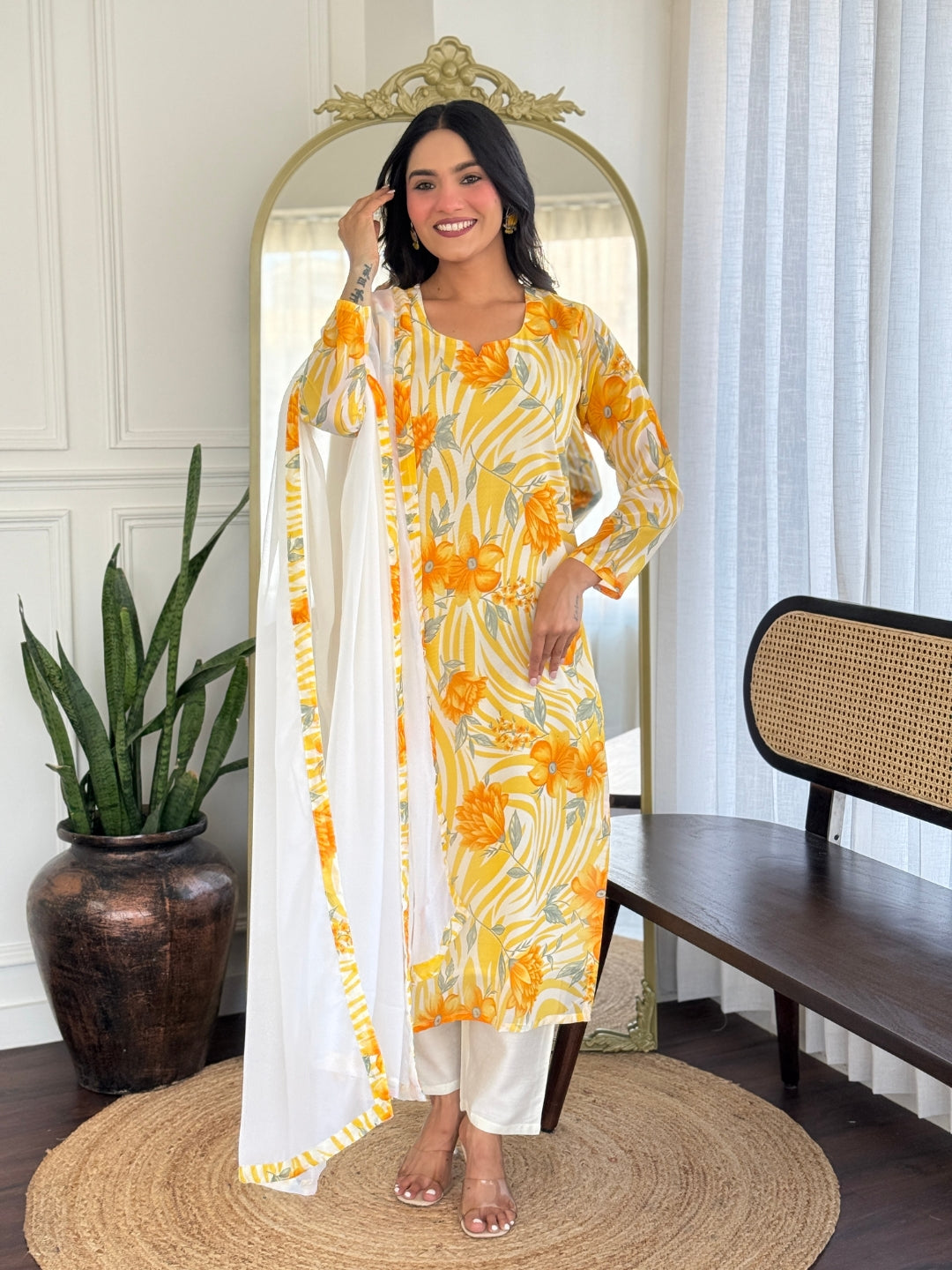 Full-length smiling model in yellow and white floral georgette kurta set with white dupatta.