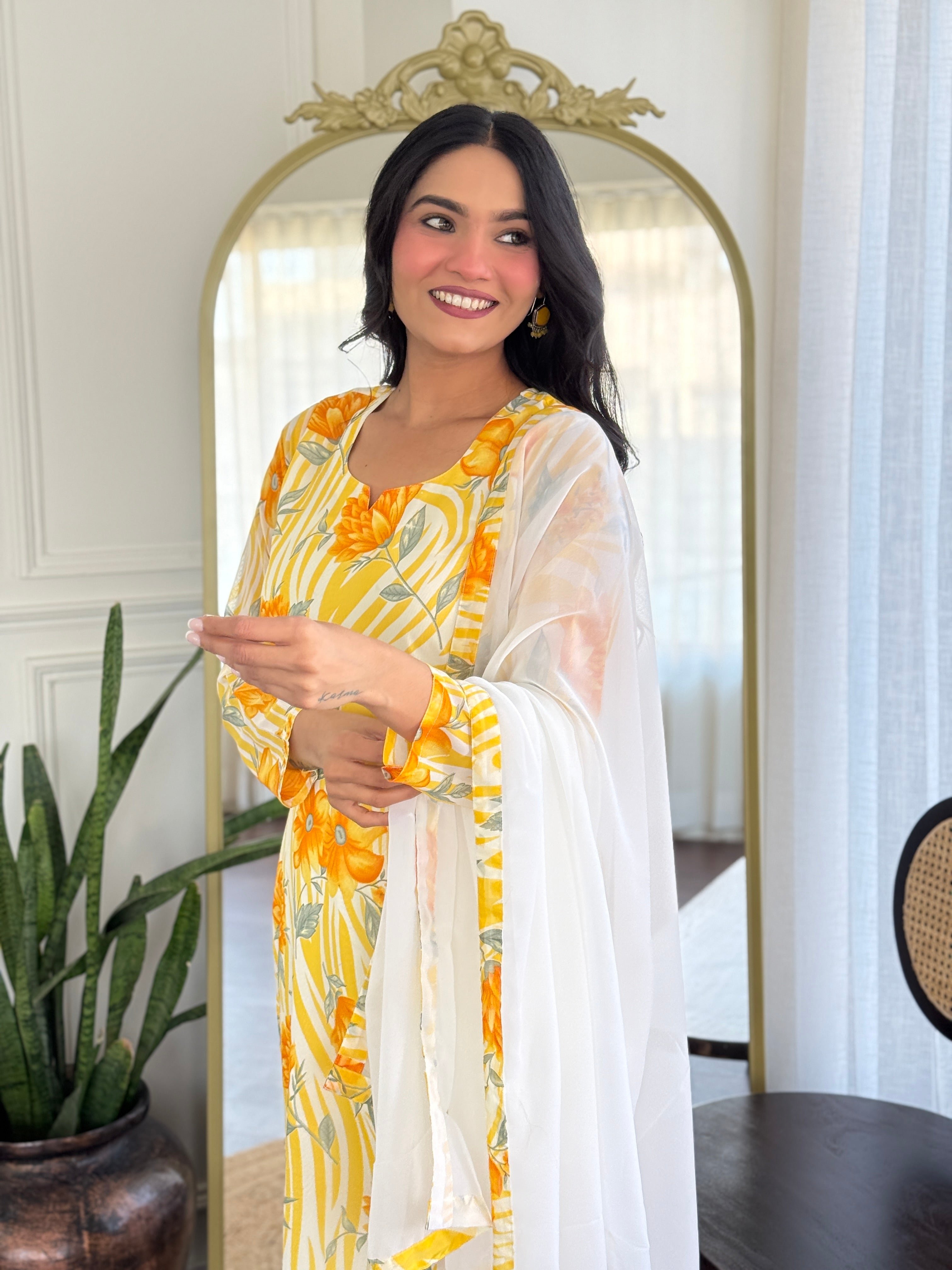 Close-up of smiling model in yellow floral kurta, showing details of the print and elegant dupatta drape.