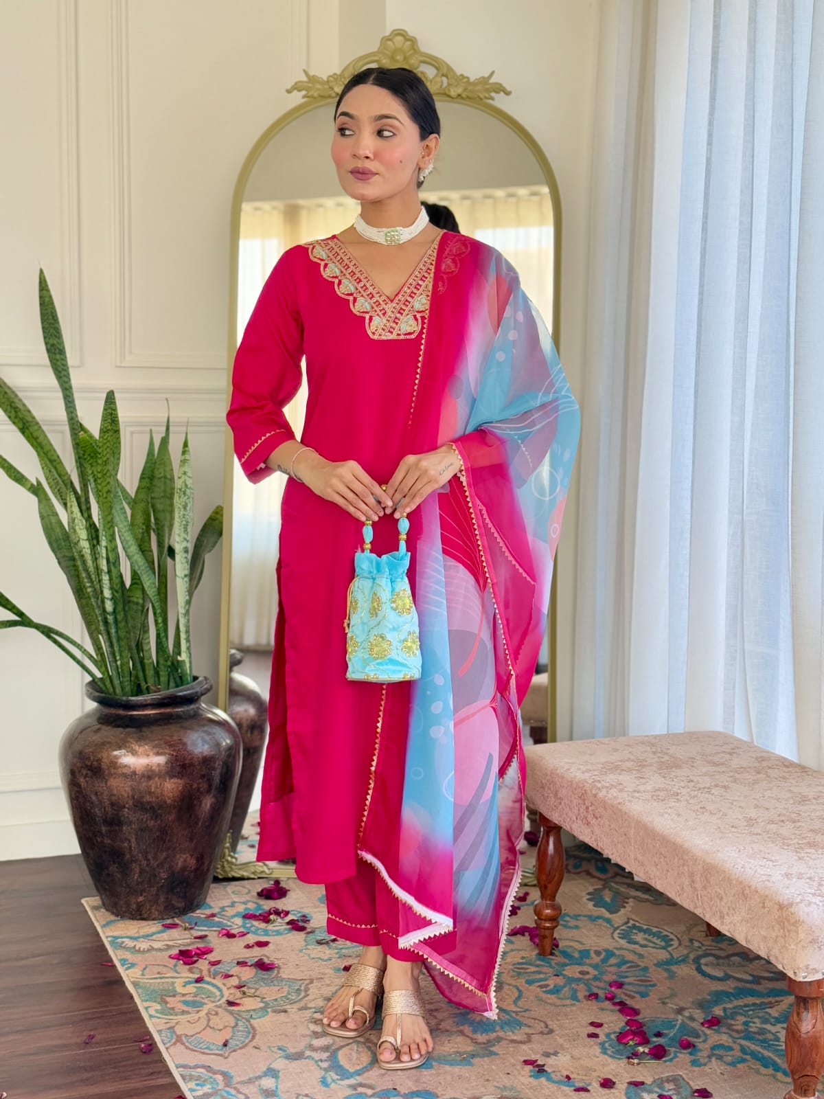 Front view of a woman showcasing the hot pink rayon slub kurti with matching pants and a multi-colored floral printed dupatta.