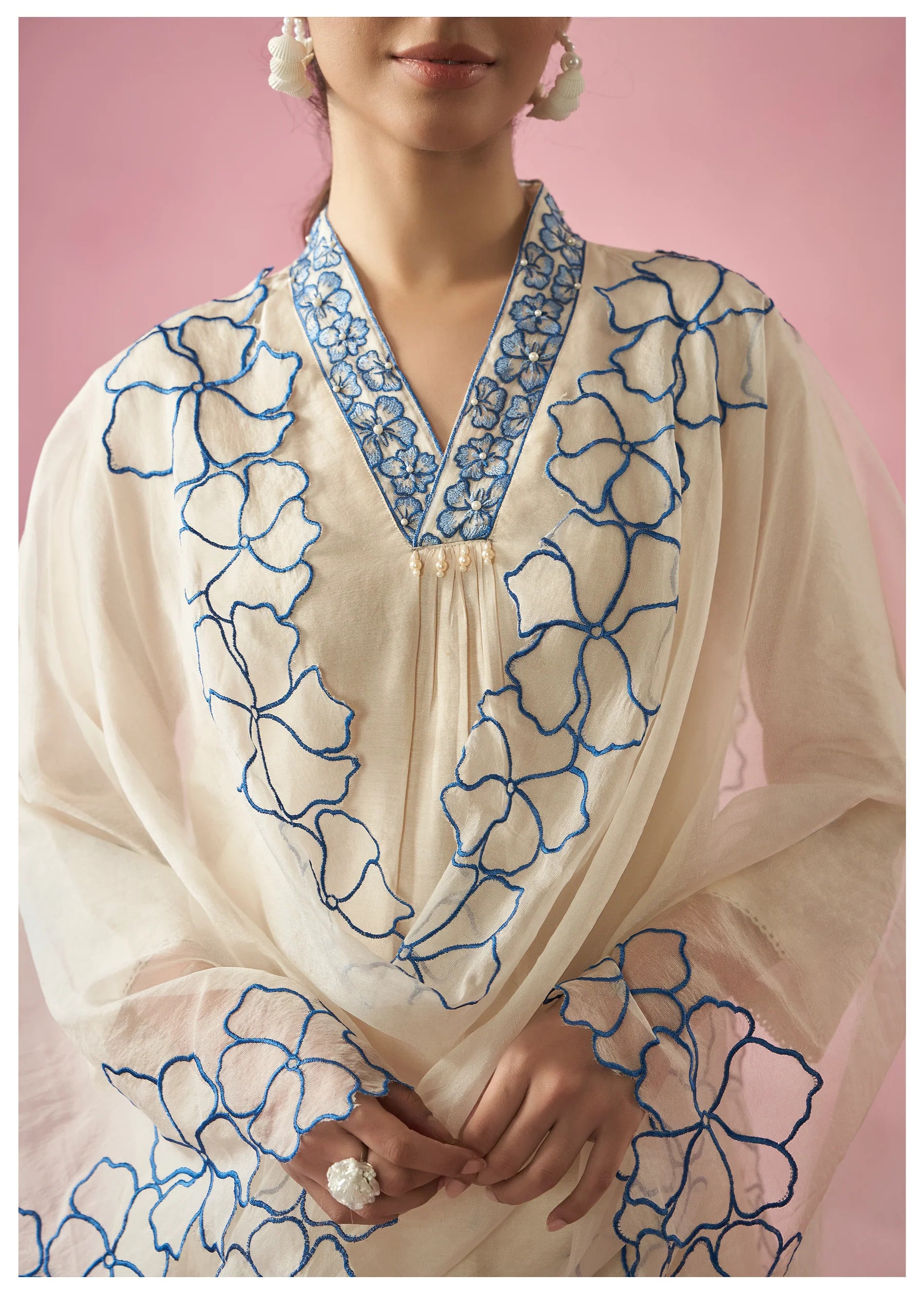 Detailed shot of the vibrant blue floral embroidery on the TRENDBUY pure organza dupatta and the upper bodice of the white kurti, showing fabric texture.