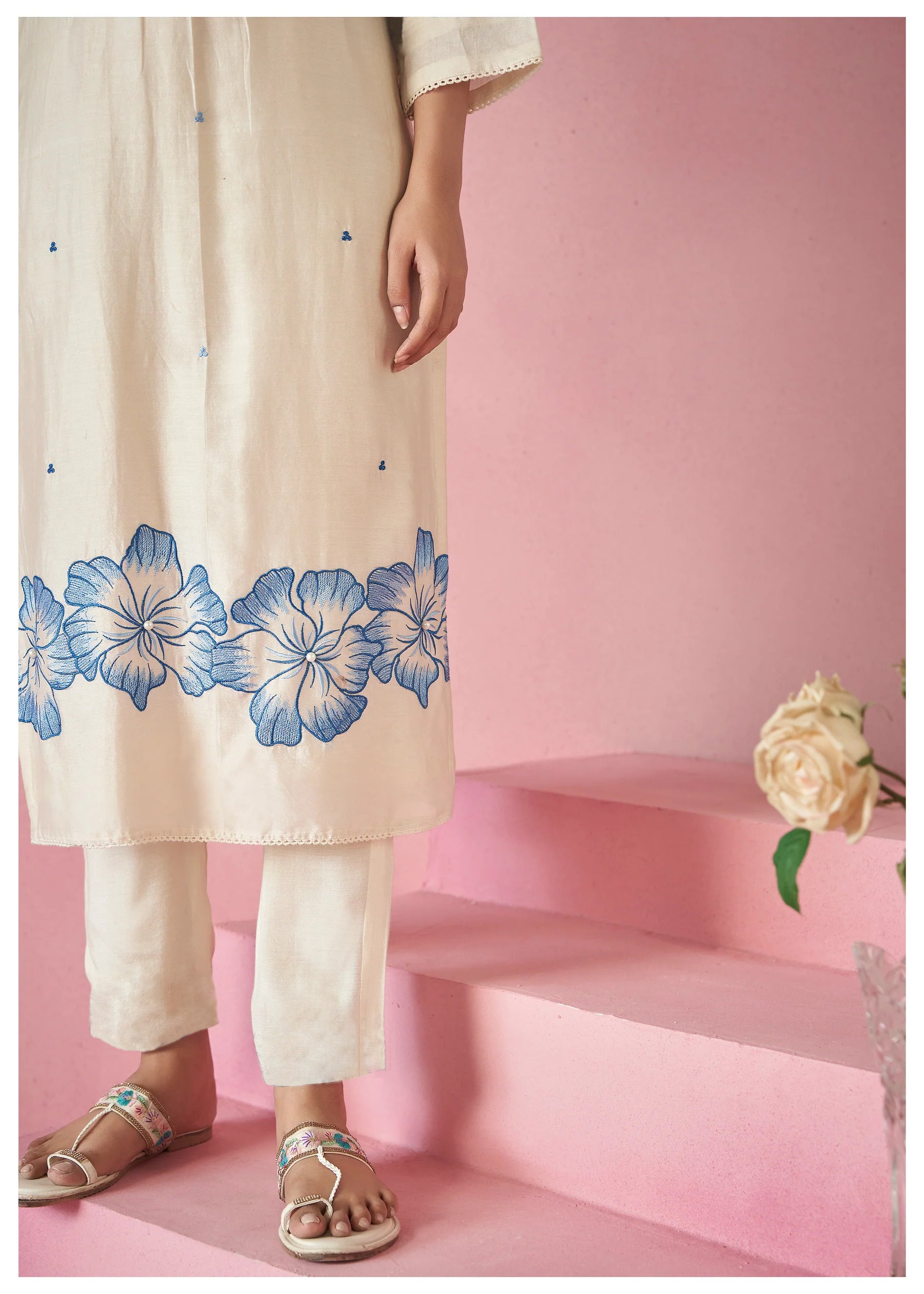Bottom detail of the TRENDBUY white embroidered kurti hem, matching fitted pant, and elegant footwear, showcasing the lower floral design.