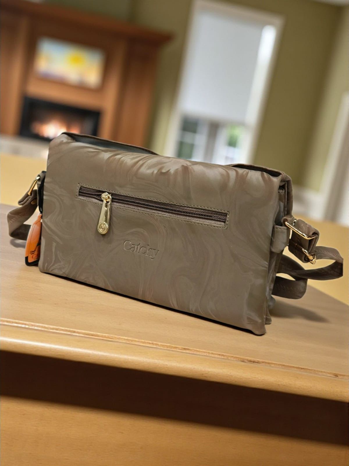 The Catchy crossbody bag in brown marbled velvet with a large statement bow.