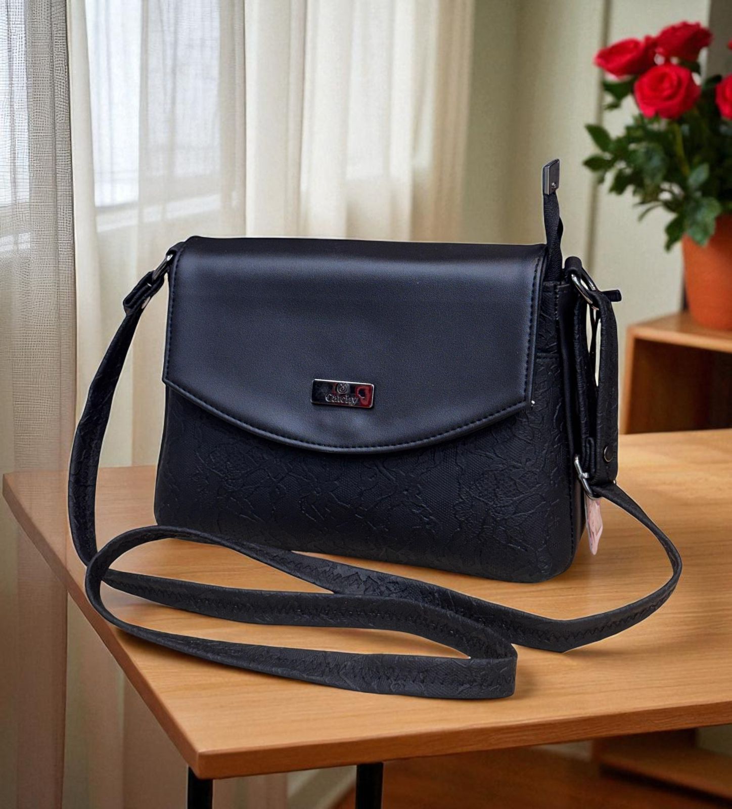 The elegant black Catchy crossbody bag with a floral lace pattern and smooth flap