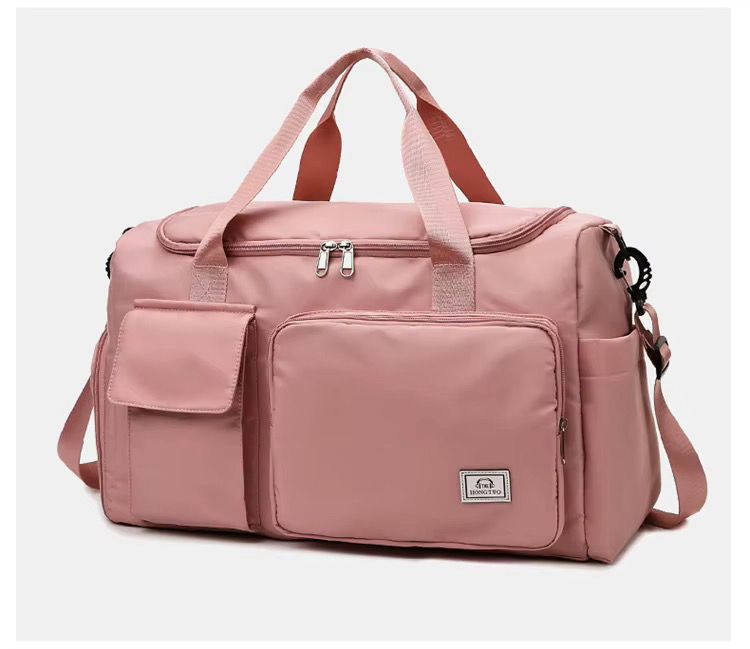 Pink duffel bag with multiple pockets and a visible brand logo on a light gray background