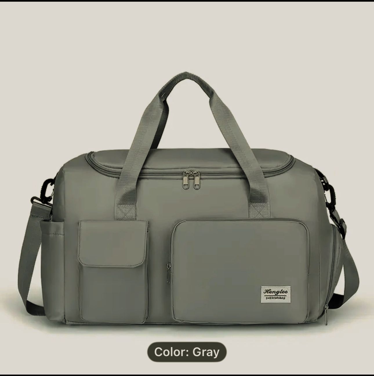 Gray duffel bag with shoulder straps on a light gray background