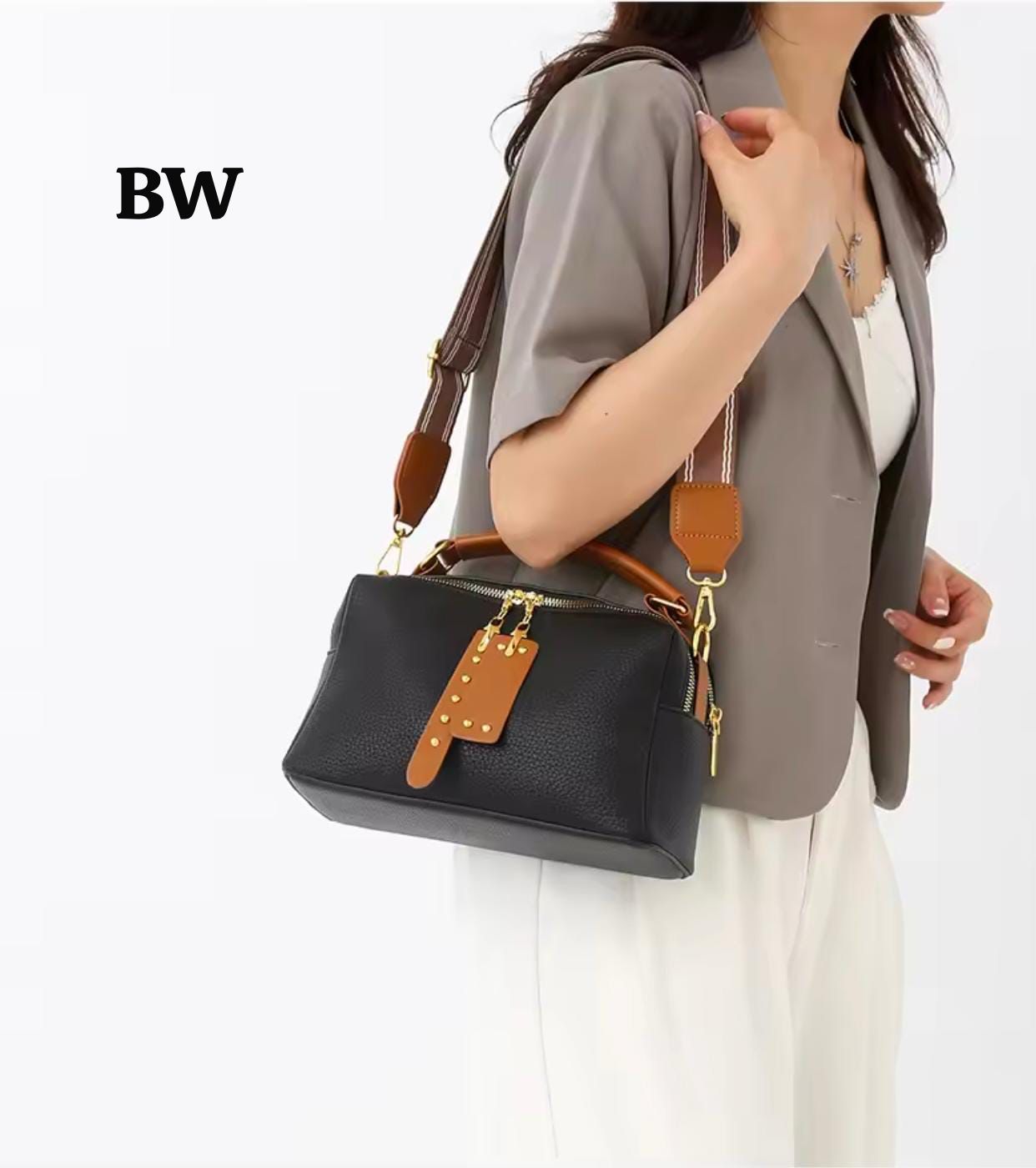 A woman wearing the black crossbody bag with the long striped strap