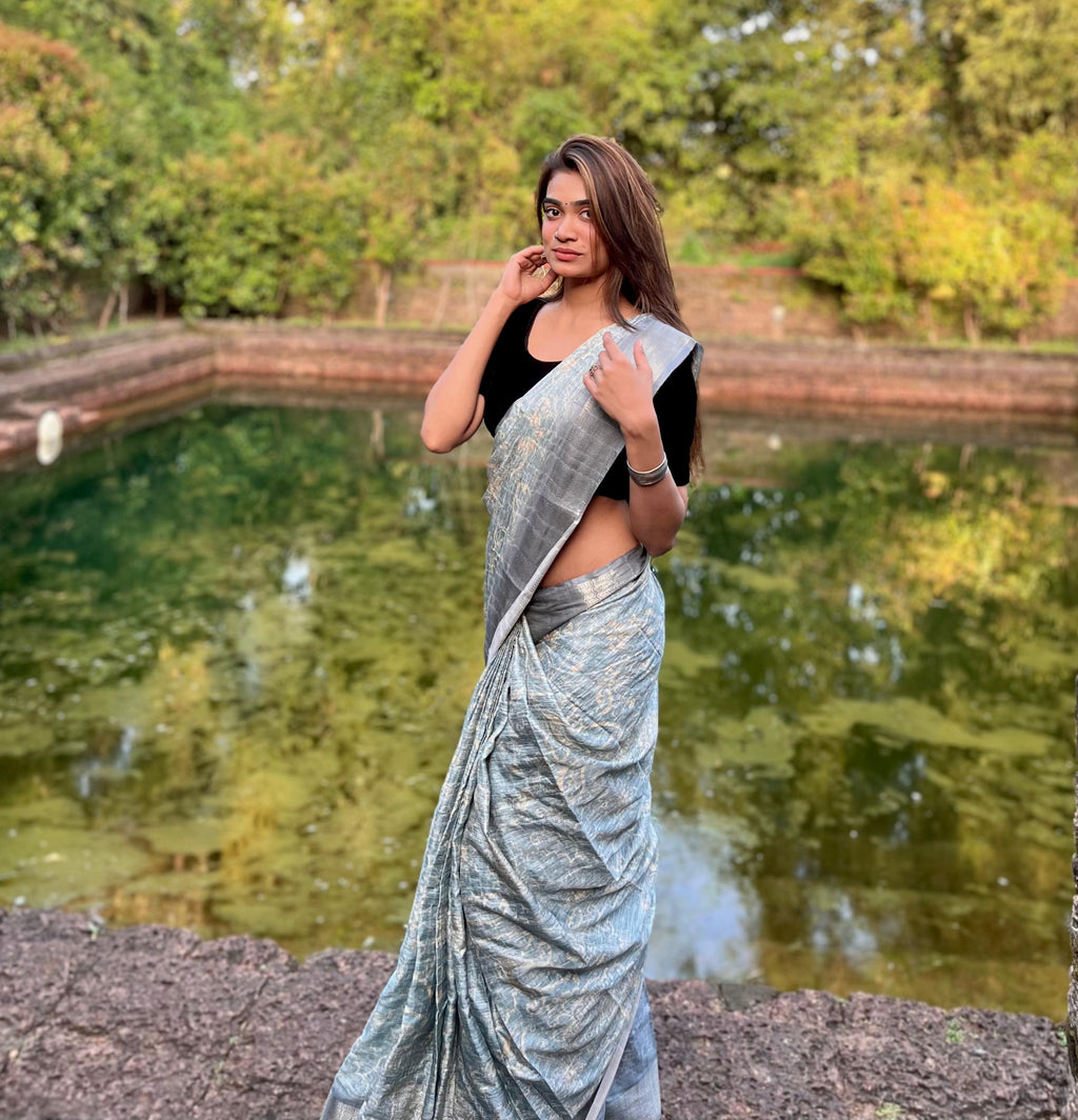 Grey printed saree draped elegantly, displaying its unique pattern.