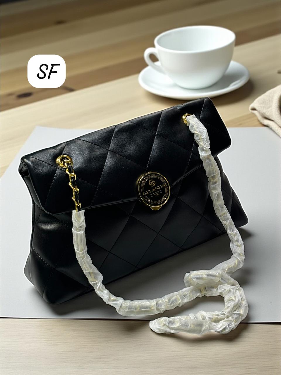 TRENDBUY Black Quilted Sling Bag resting on a table alongside a white coffee cup, emphasizing its everyday elegance and premium finish.