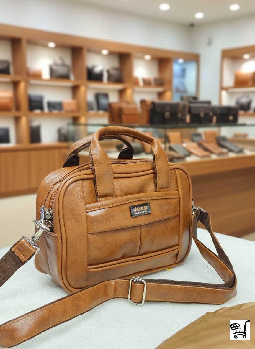 Close-up view of the tan brown JEEP Buluo leather-look hand and shoulder bag on a table in a retail store.