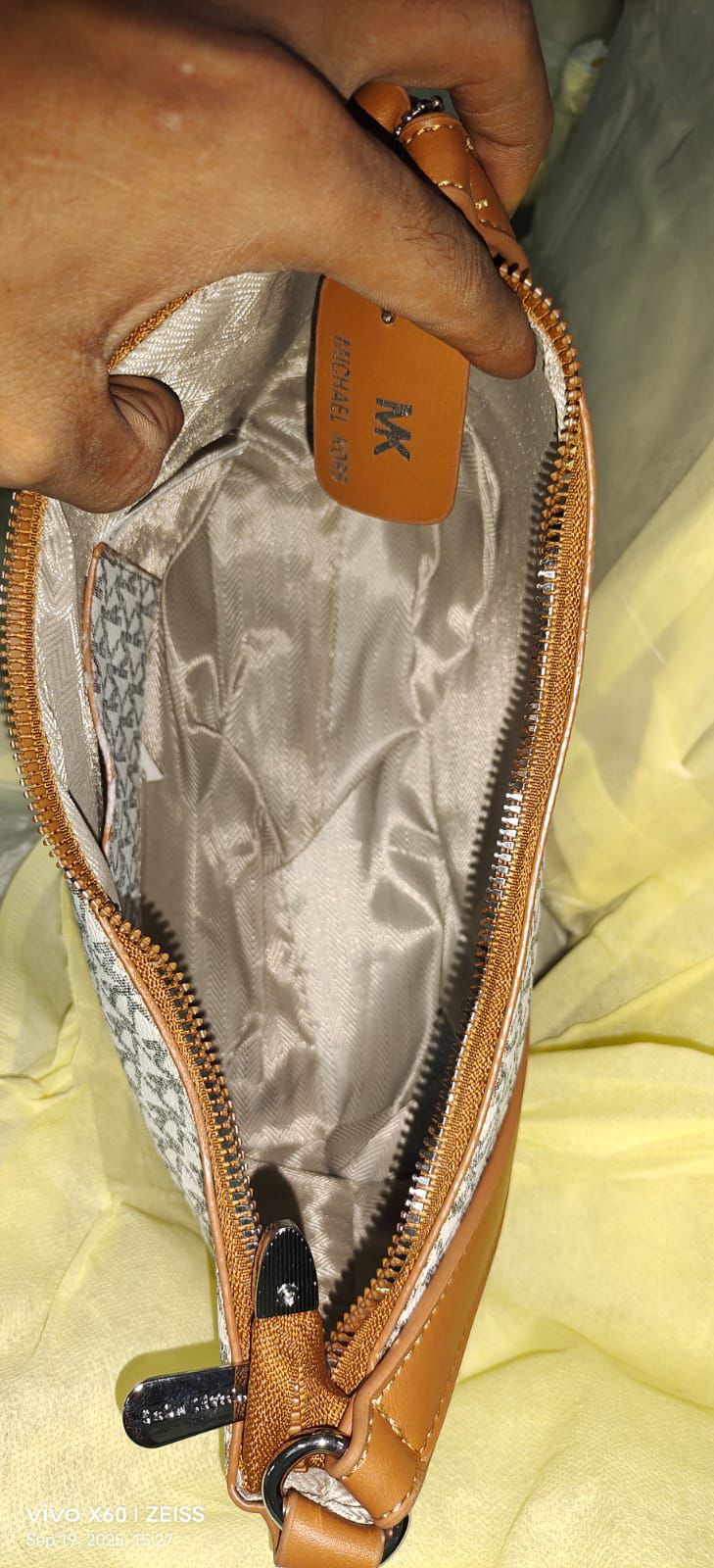 Interior view of the TRENDBUY Michael Kors MK monogram bag, highlighting the quality lining, branded tag, and zipper detail.