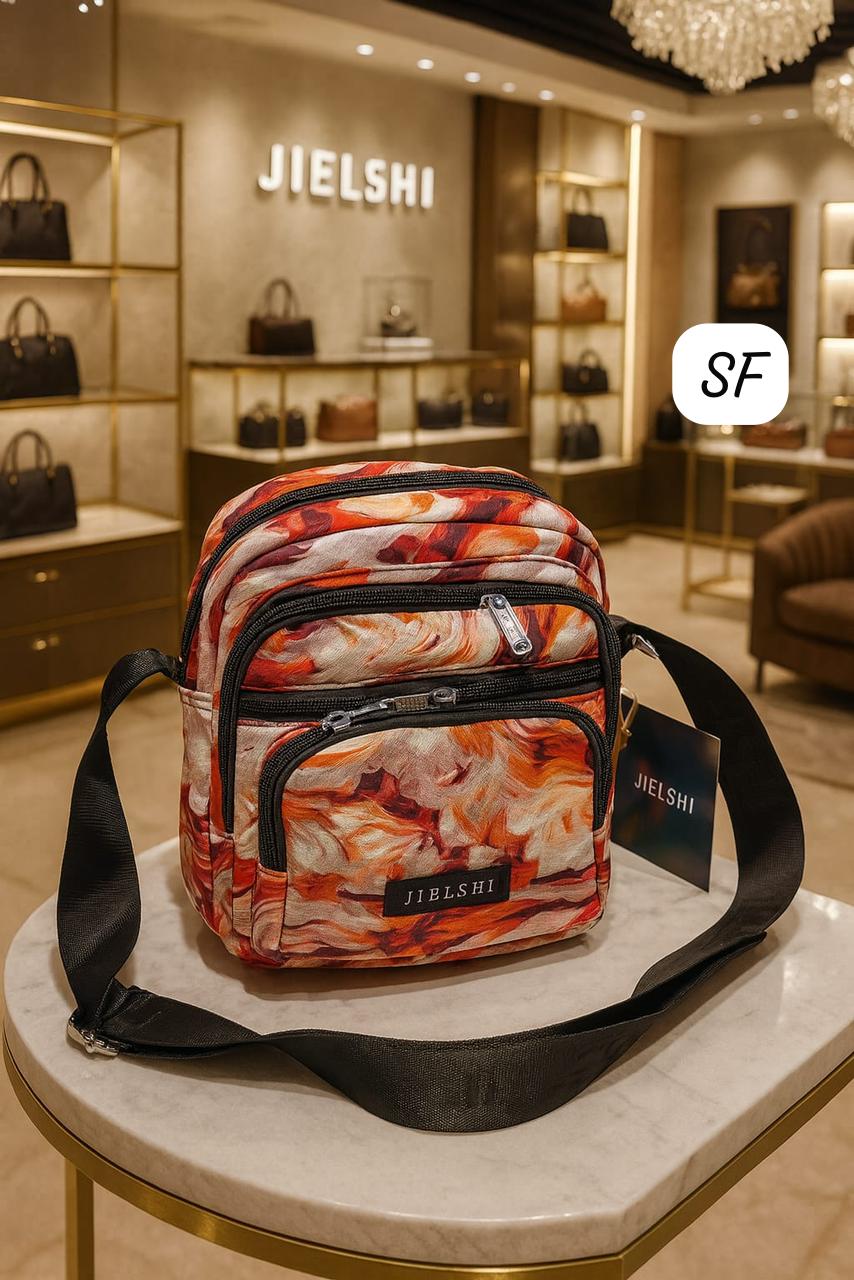 TRENDBUY Jielshi multi-compartment sling bag with abstract orange pattern, displayed in a luxury boutique.