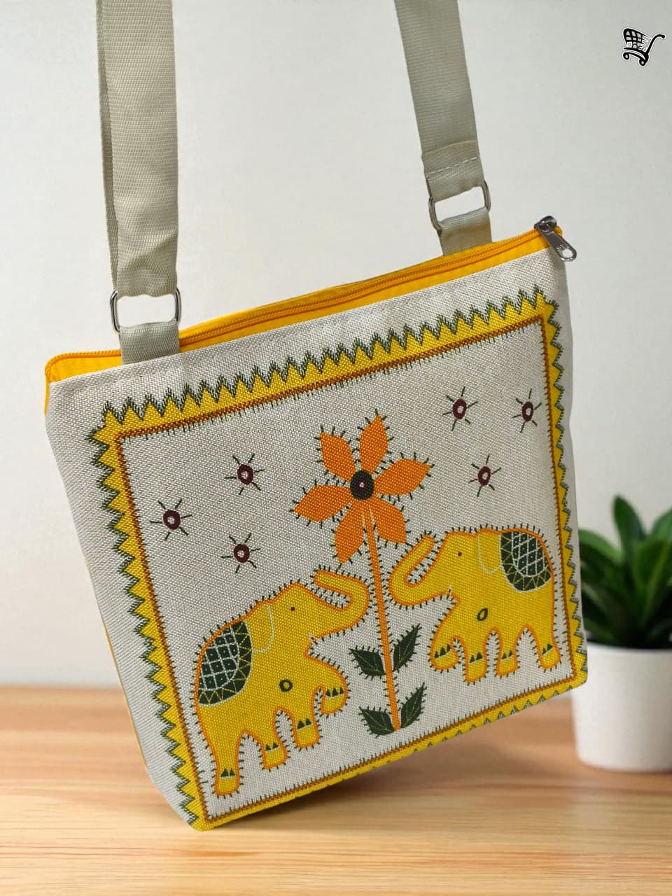 TRENDBUY yellow elephant print jute sling bag with adjustable strap, displayed frontally against a light background.
