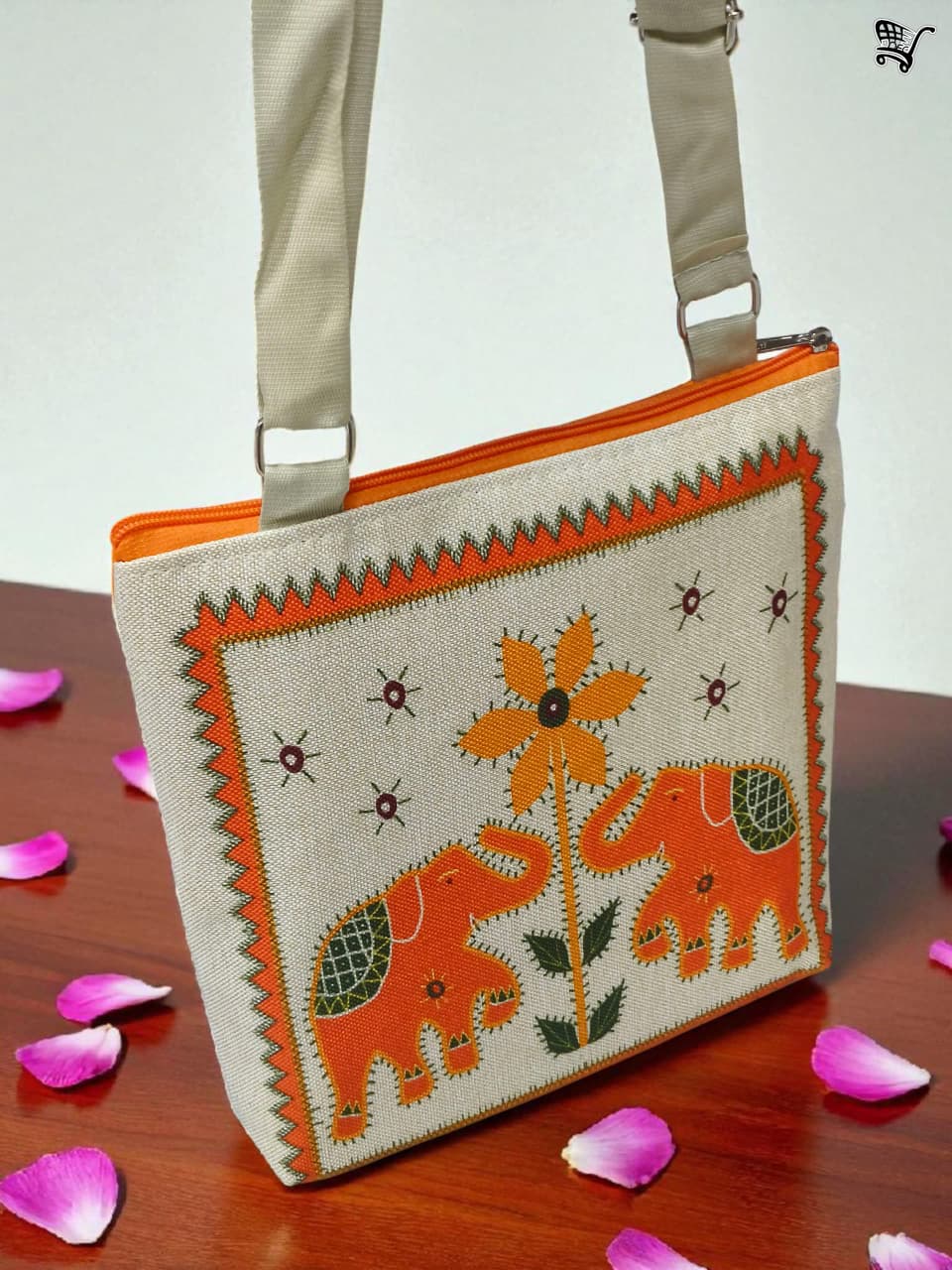 TRENDBUY orange elephant print jute crossbody bag with rose petals on a wooden surface, front view.