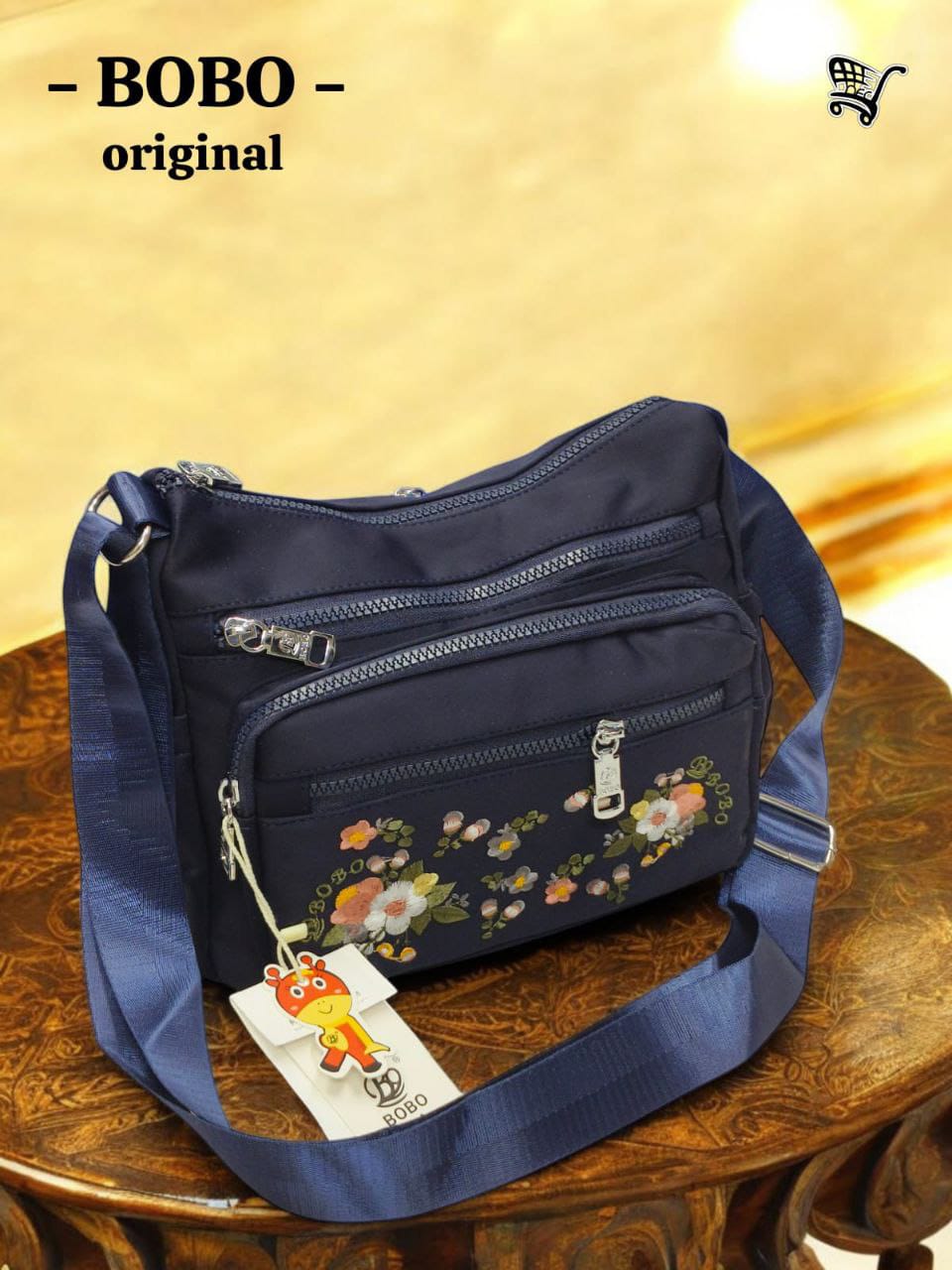 TRENDBUY BOBO Original navy blue floral nylon crossbody messenger bag on wooden table