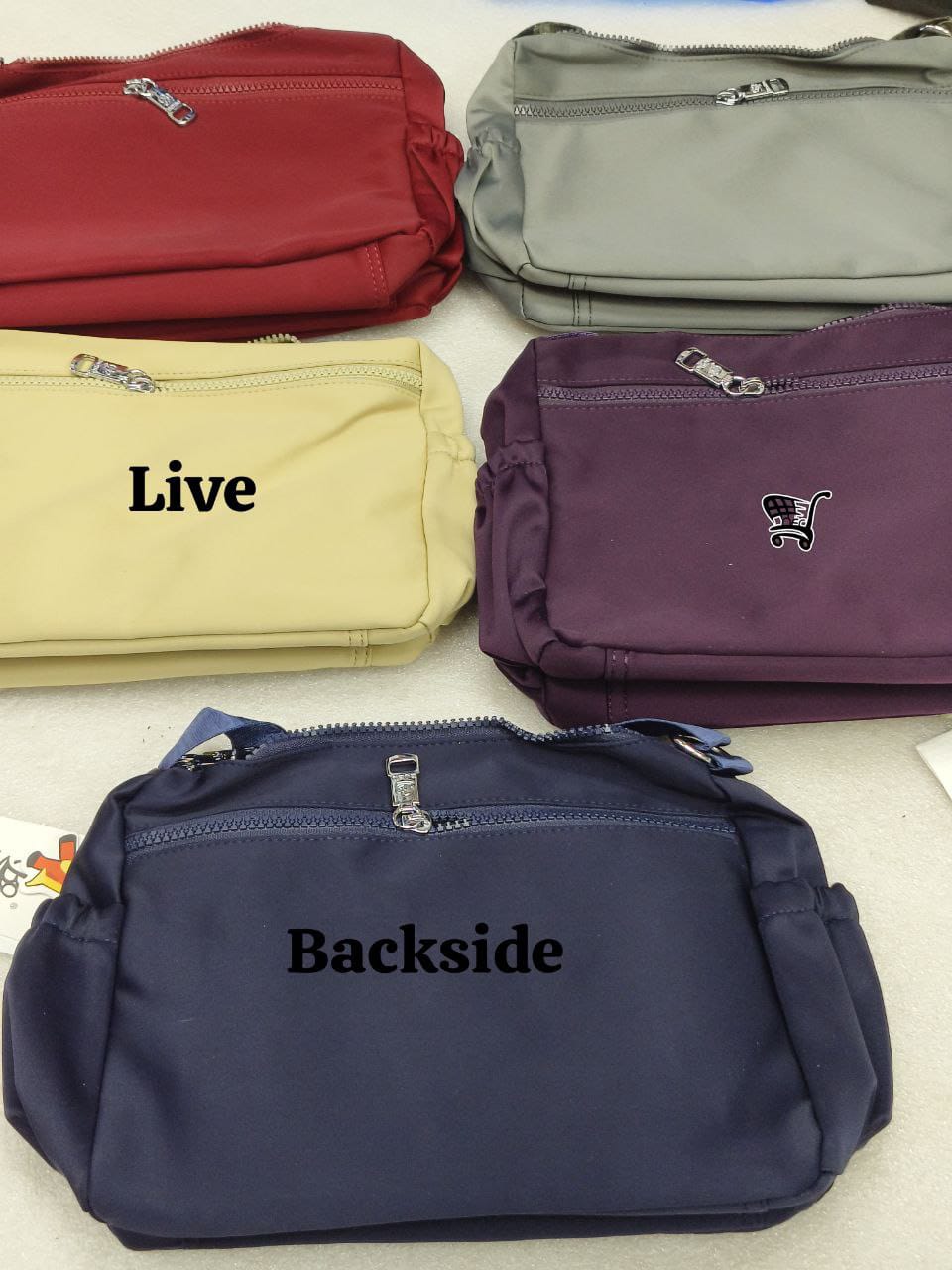 Assortment of TRENDBUY BOBO Original nylon bags in red, beige, grey, purple, and navy blue, showcasing front and back