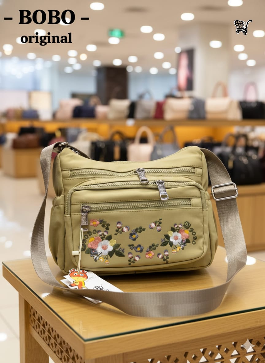 TRENDBUY BOBO Original beige floral messenger bag displayed in a store with other handbags in background