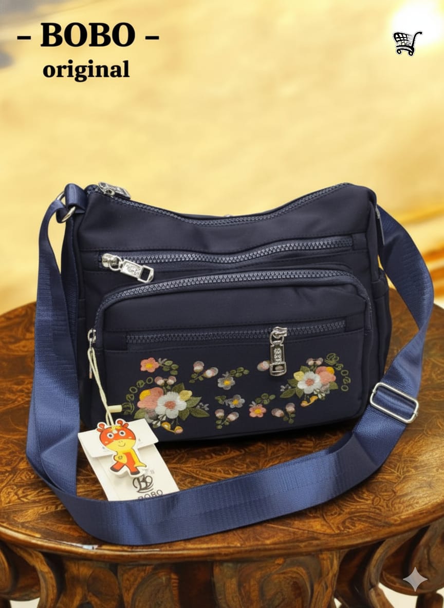 TRENDBUY BOBO Original navy blue floral travel shoulder bag resting on a rich wooden surface