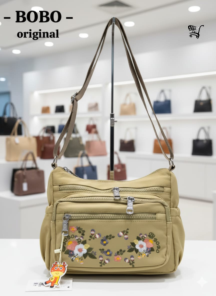TRENDBUY BOBO Original beige floral crossbody bag hanging on a display stand in a retail environment