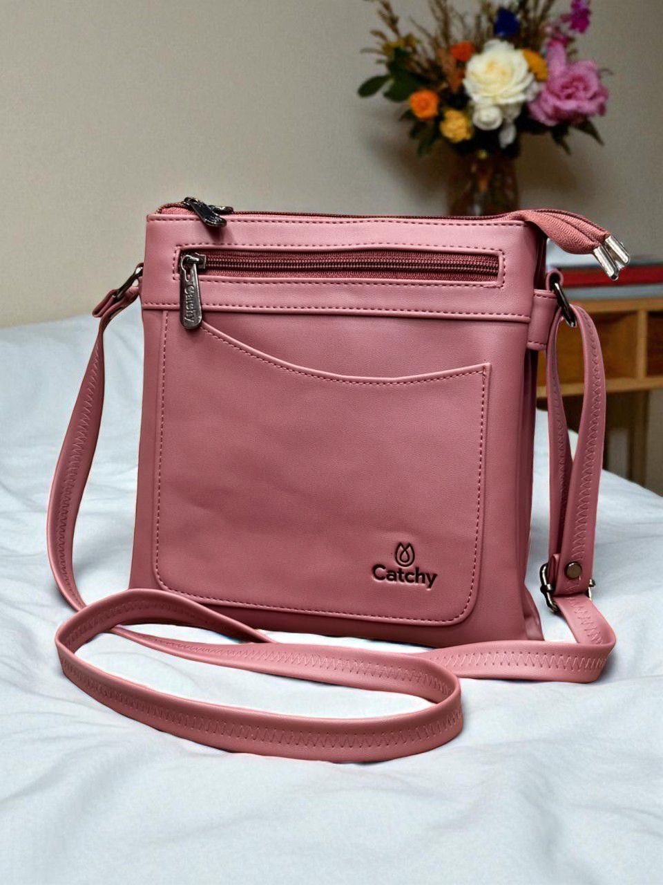 Dusty Pink Catchy multi-compartment crossbody bag in a cozy room setting with plants.