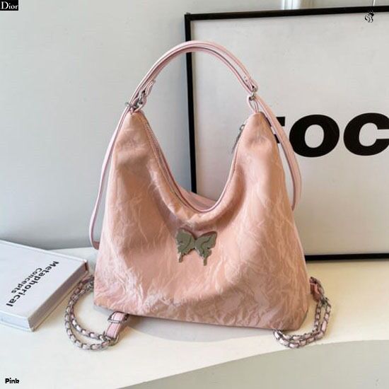 Front view of a pink 2-in-1 convertible handbag with a shimmering butterfly accent, styled as a shoulder bag.