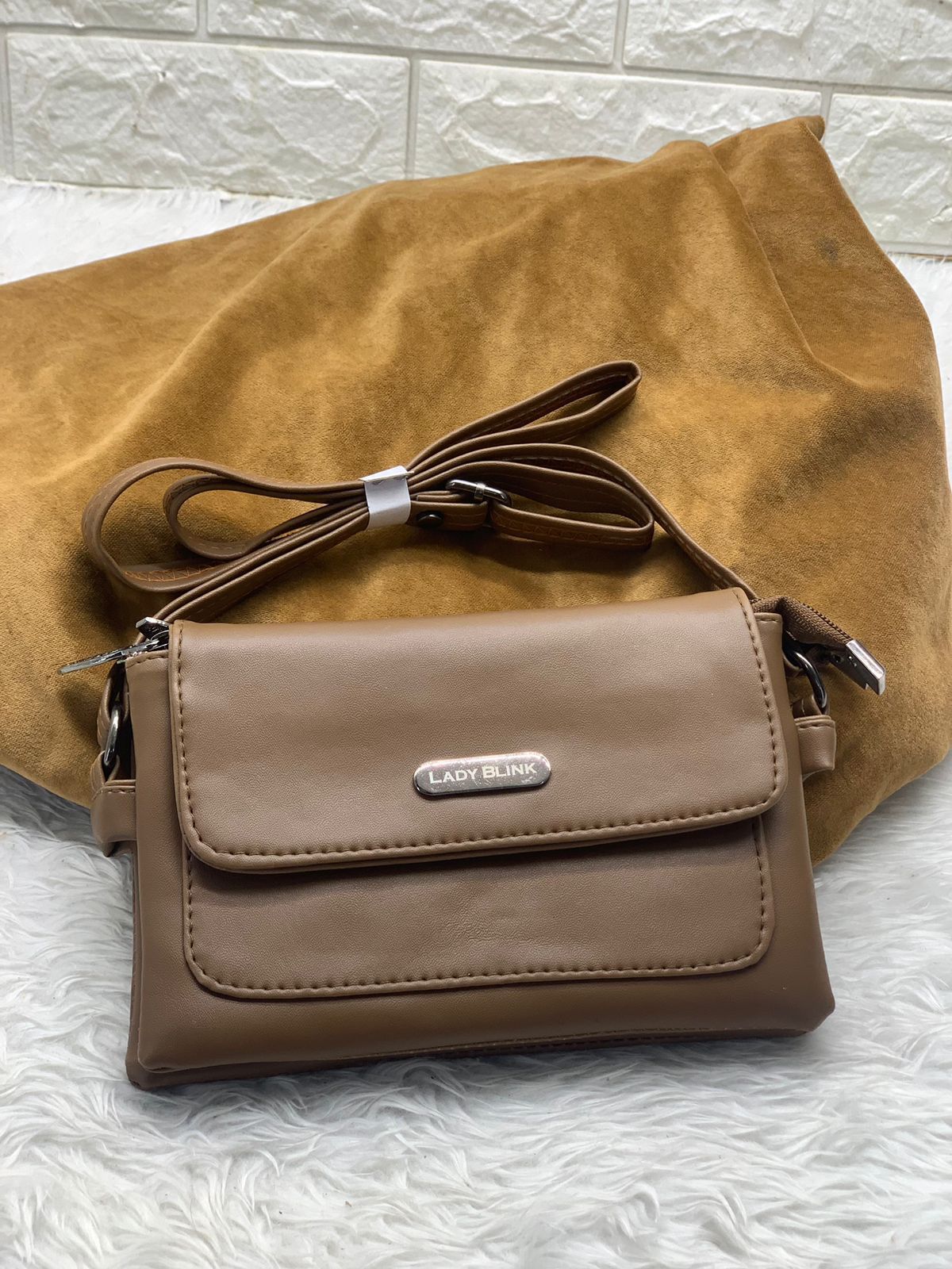TRENDBUY trendy sling bag in taupe brown PU leather, front view with long strap.