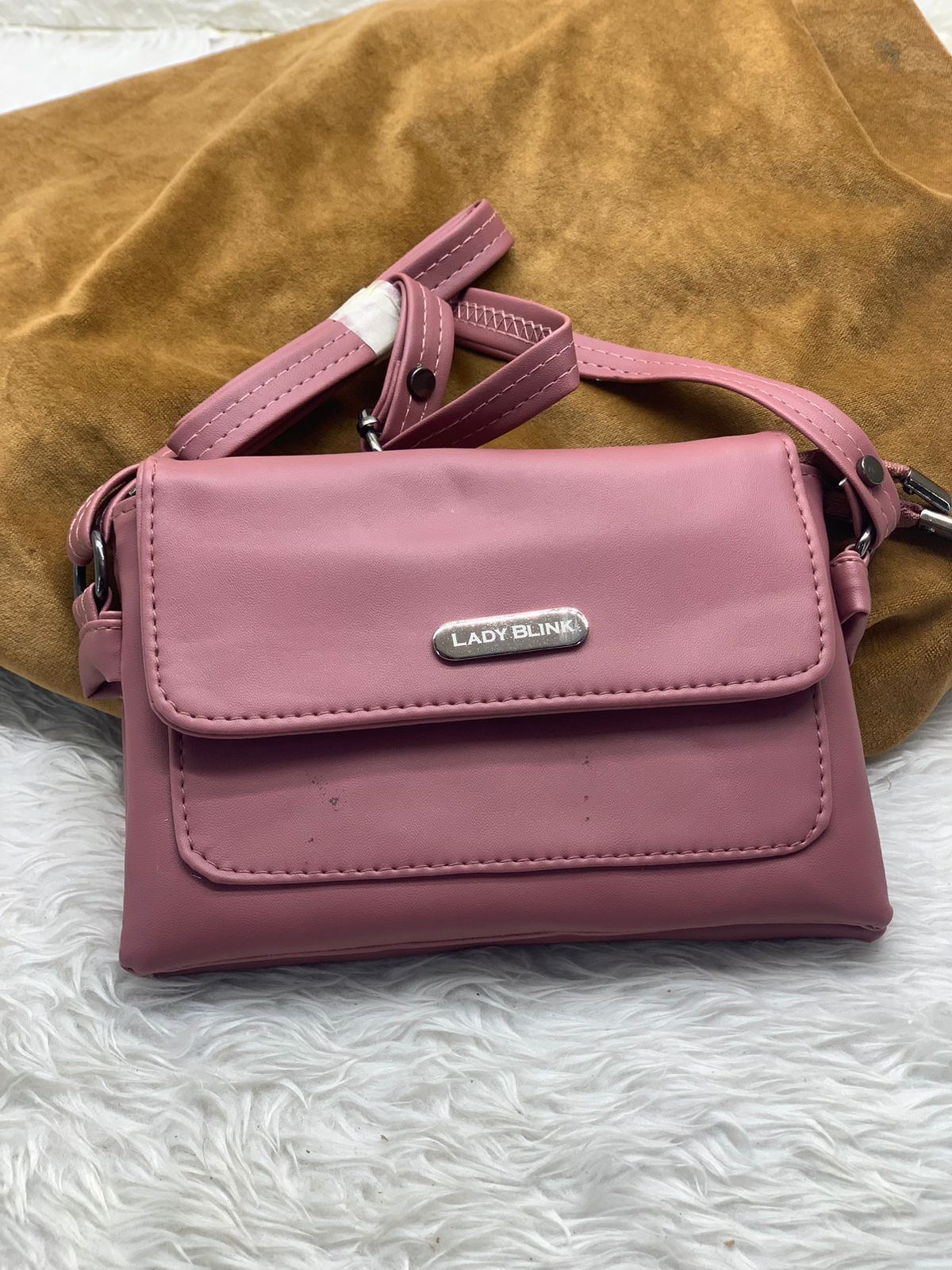 TRENDBUY coral pink PU leather sling bag, featuring front flap and metal logo accent.