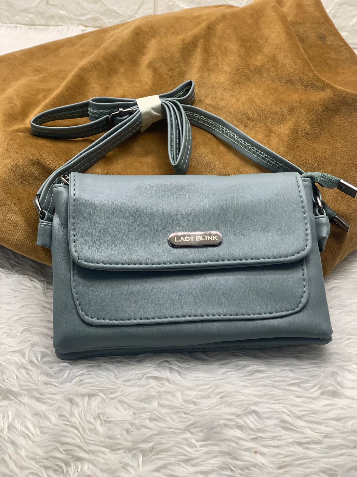 TRENDBUY light blue PU leather sling bag, showcasing its sleek design and adjustable strap.
