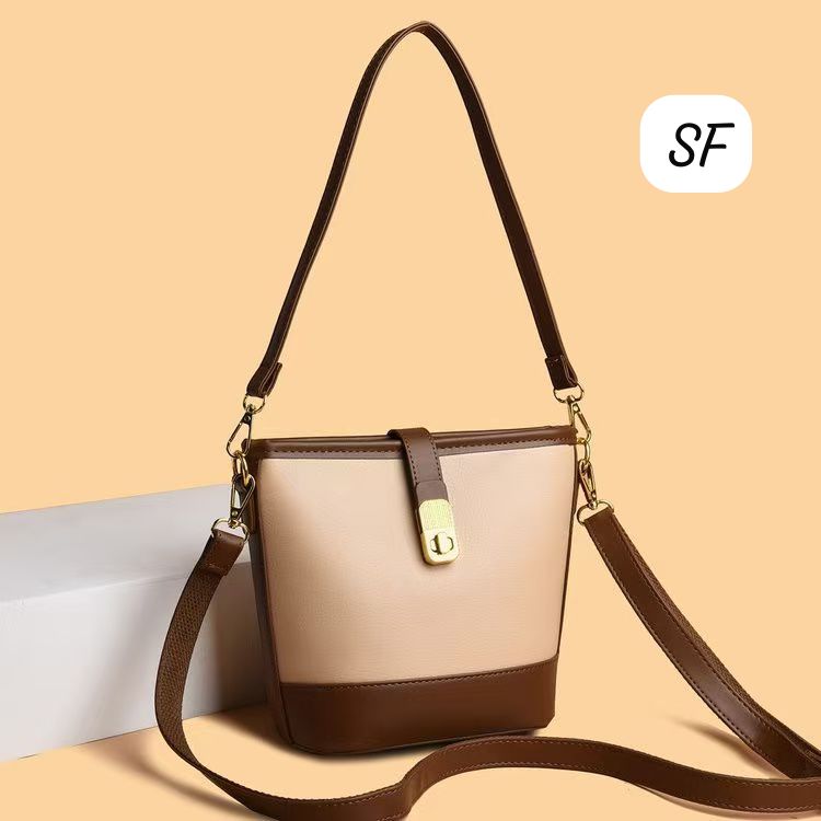 Beige and brown crossbody bag with long strap against a minimalist background.