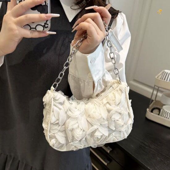 Model wearing TRENDBUY Charles & Keith style 3D rose textured white sling bag with a chic collared top.