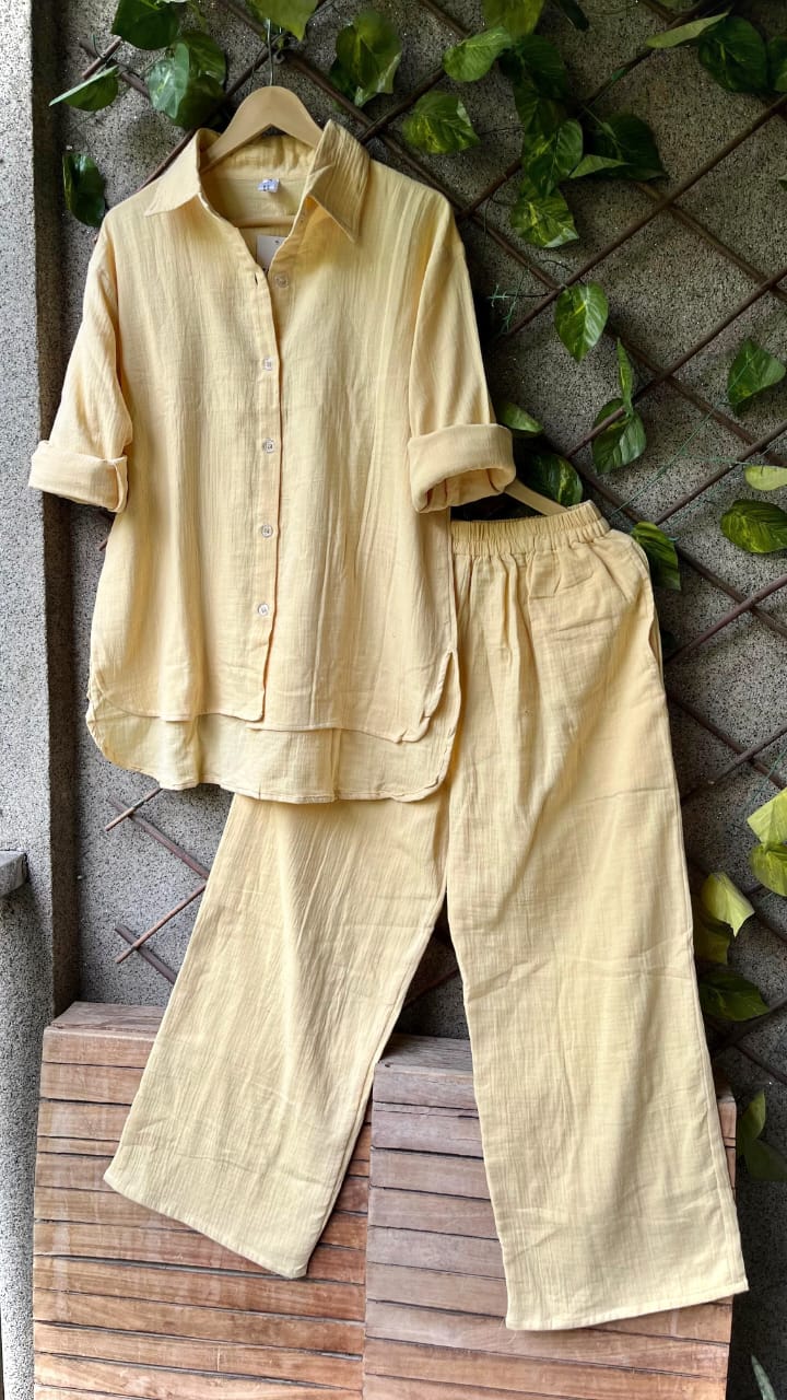 Soft Pastel Yellow Updown Mul Mul Cotton Cord Set, perfect for summer comfort against green leaves.