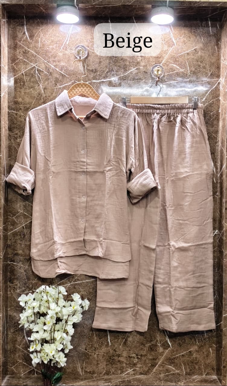 Sophisticated Beige Mul Mul Cotton Cord Set, styled with white floral accents on a luxurious marble wall.