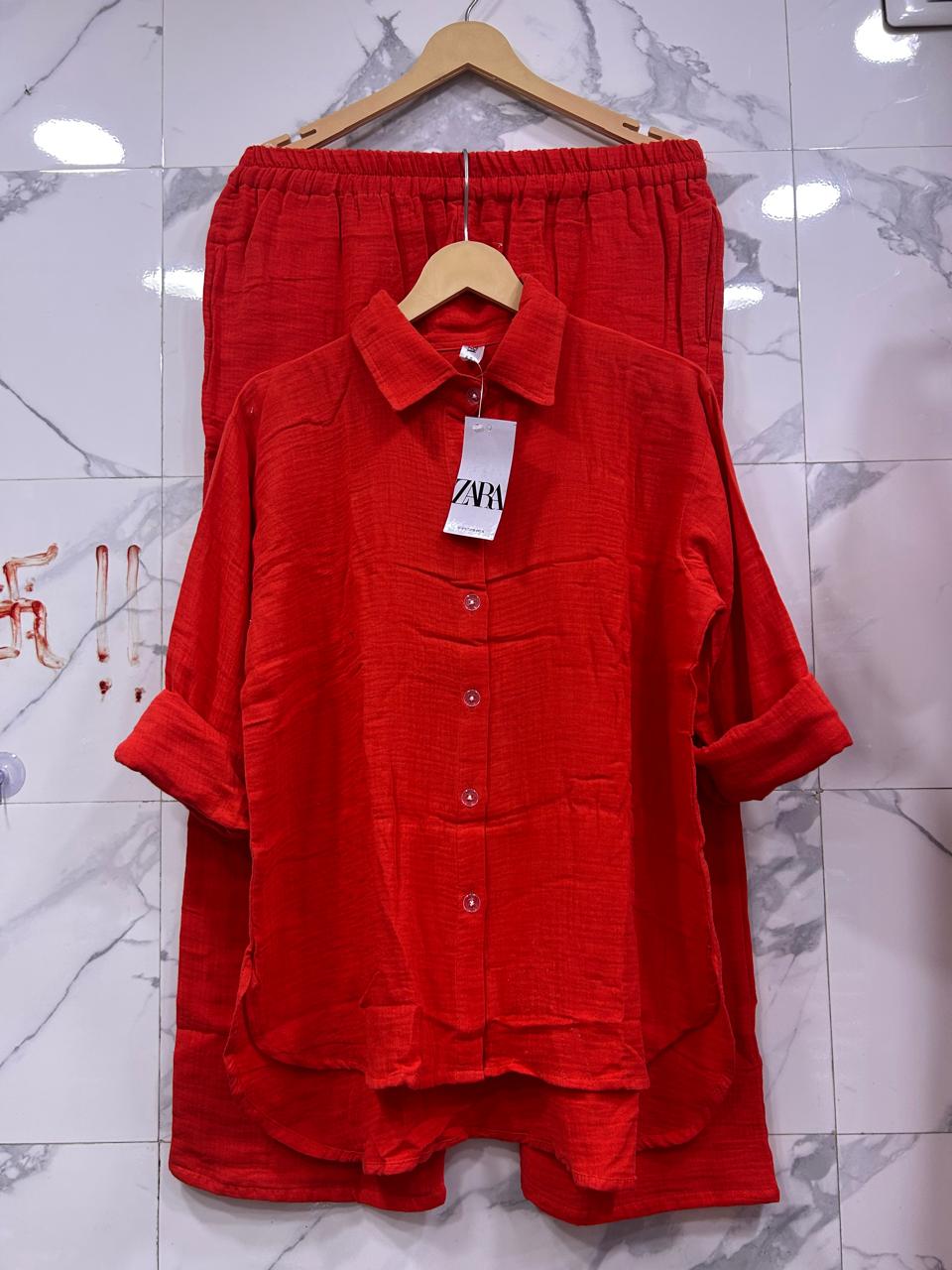 Full view of Red Mul Mul Cotton Updown Cord Set, showcasing the bold color and relaxed fit on marble.