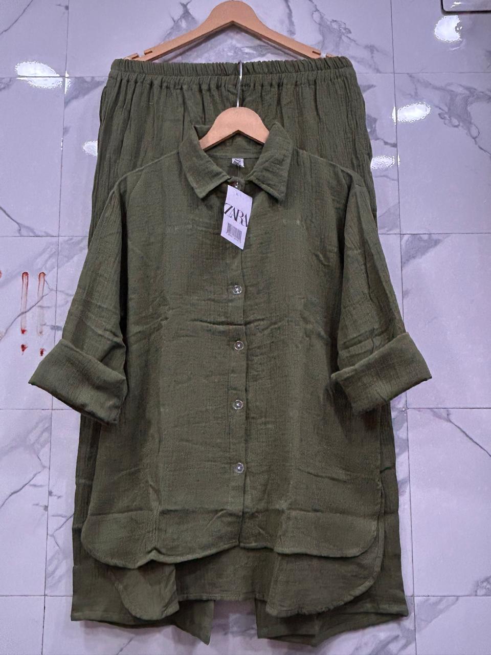 Full view of Olive Green Mul Mul Cotton Cord Set, with a Zara tag, draped on a wooden hanger.