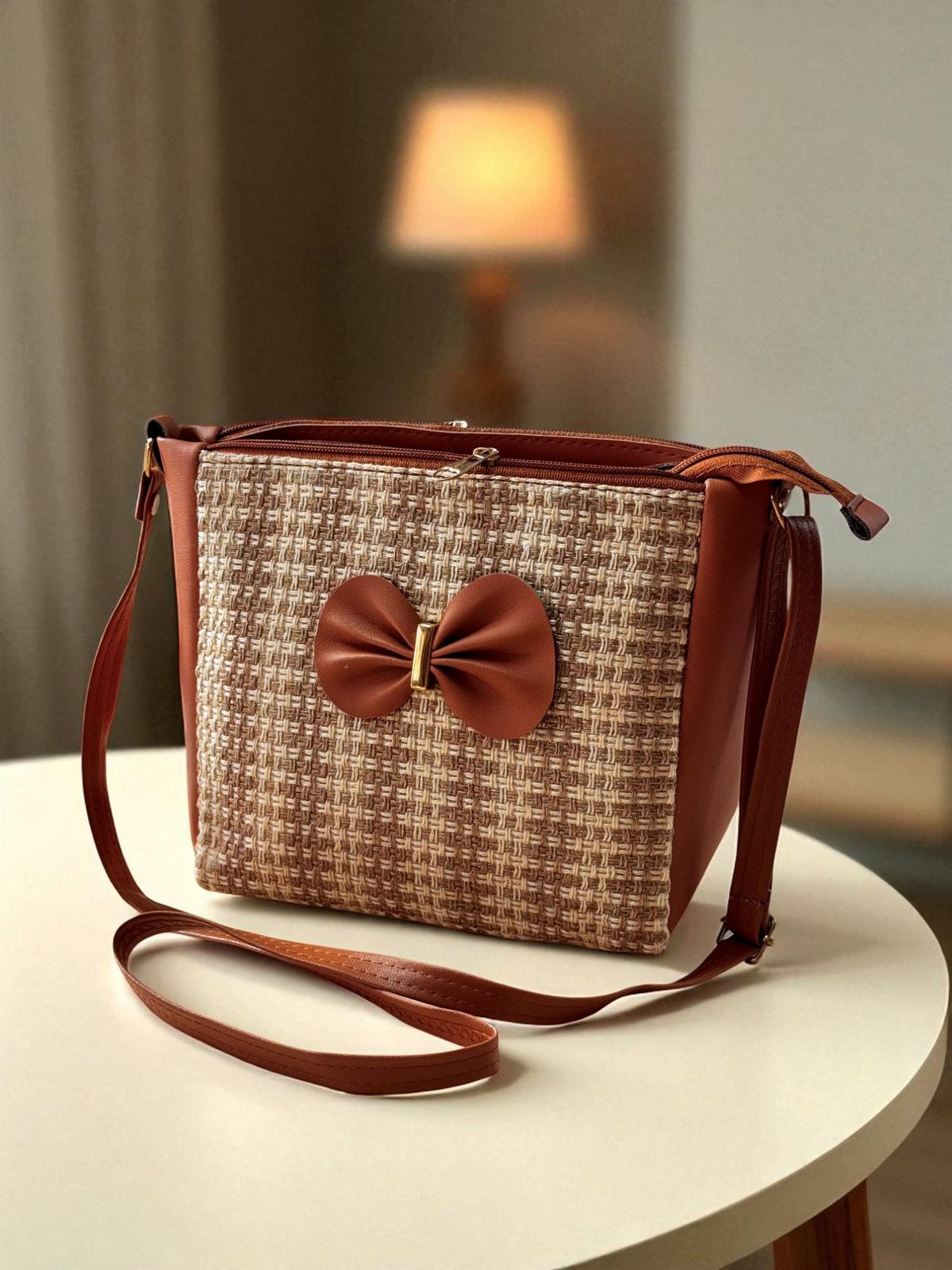 TRENDBUY brown and beige checkered bucket sling bag with a brown bow detail, on a wooden table.