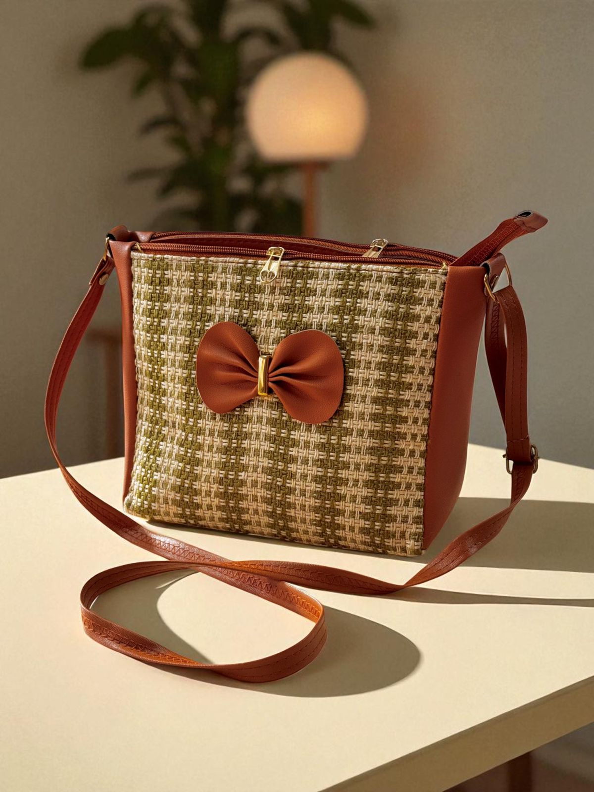 TRENDBUY green and beige checkered bucket sling bag with a brown bow detail, on a wooden table.