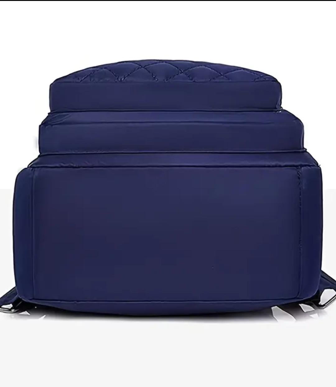 Bottom view of the navy blue quilted nylon backpack, showcasing its sturdy base.