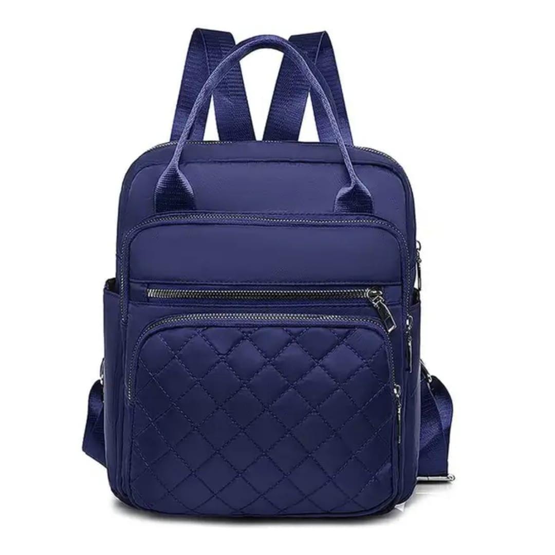 Front view of the navy blue quilted nylon backpack, highlighting top handles and adjustable shoulder straps.