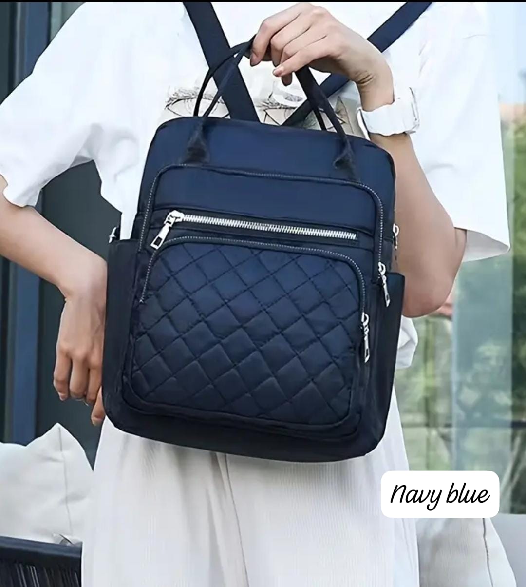 Woman casually wearing the navy blue quilted nylon backpack, confirming the 'Navy blue' color in context.