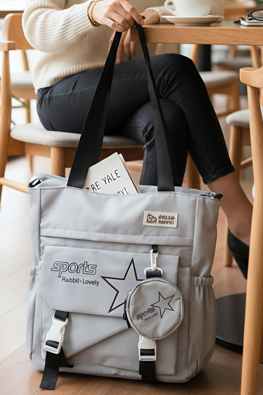 TRENDBUY Grey imported tote bag with star design and matching coin pouch, modeled by a person.
