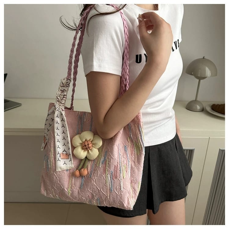 TRENDBUY pink floral charm tote bag with braided strap, carried by a woman in a white top