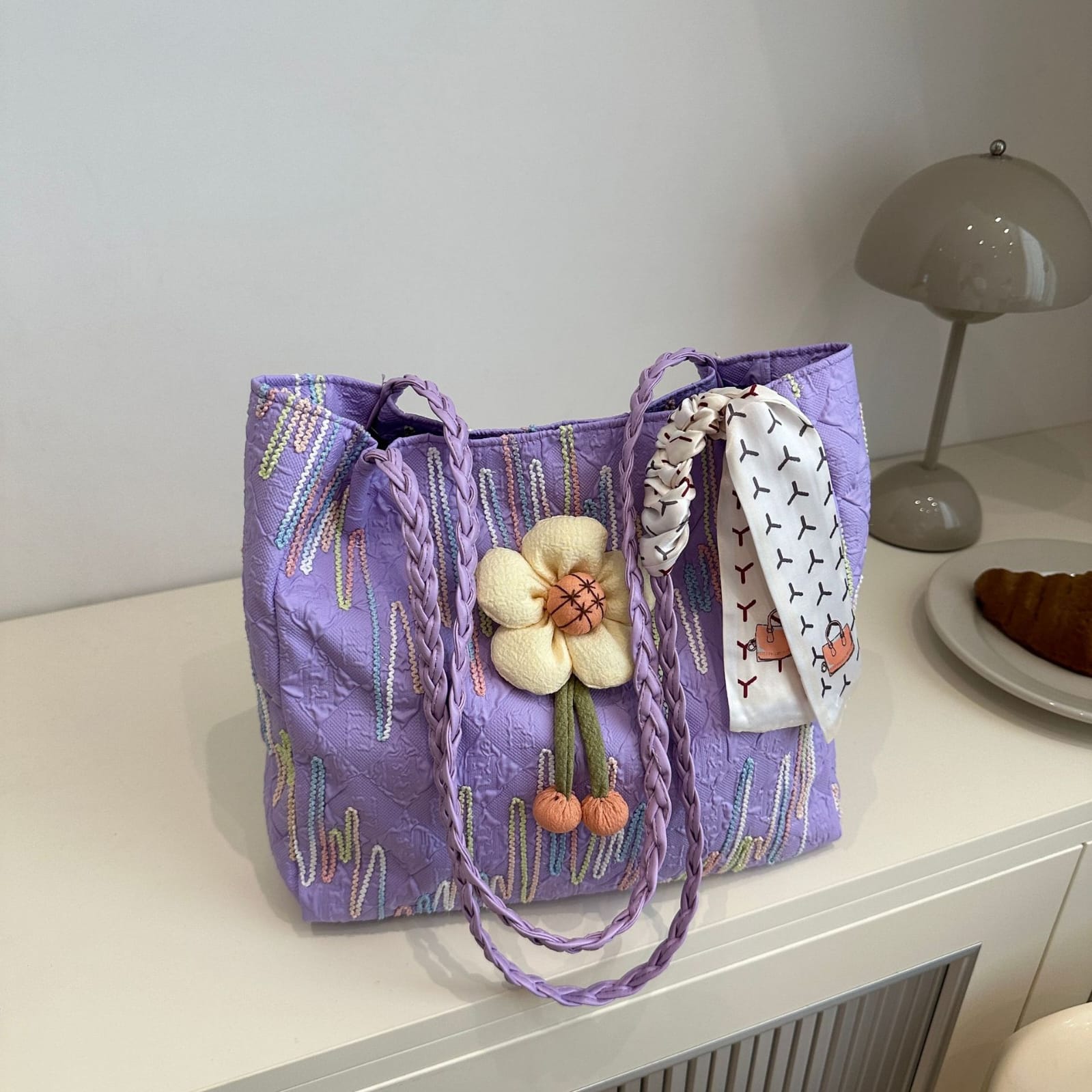 TRENDBUY purple floral charm tote bag with braided handle and accessory scarf on a white table