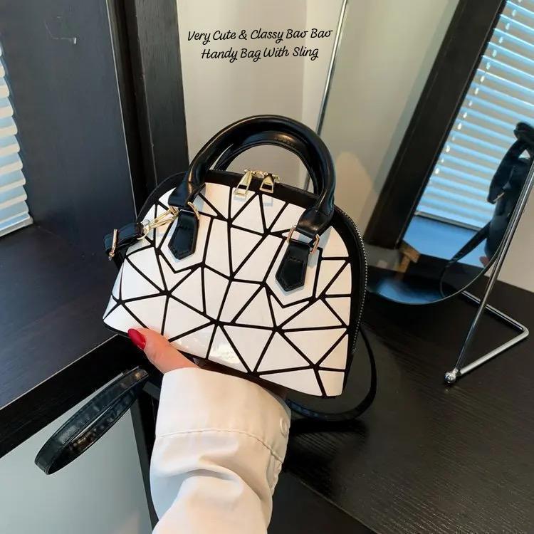 Close-up of a white geometric Bao Bao mini handbag with black trim and sling, held by hand, emphasizing its cute and classy design