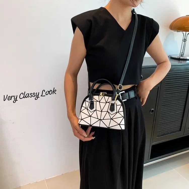 Woman wearing a white geometric Bao Bao dome handbag crossbody, paired with a black outfit, demonstrating a very classy look