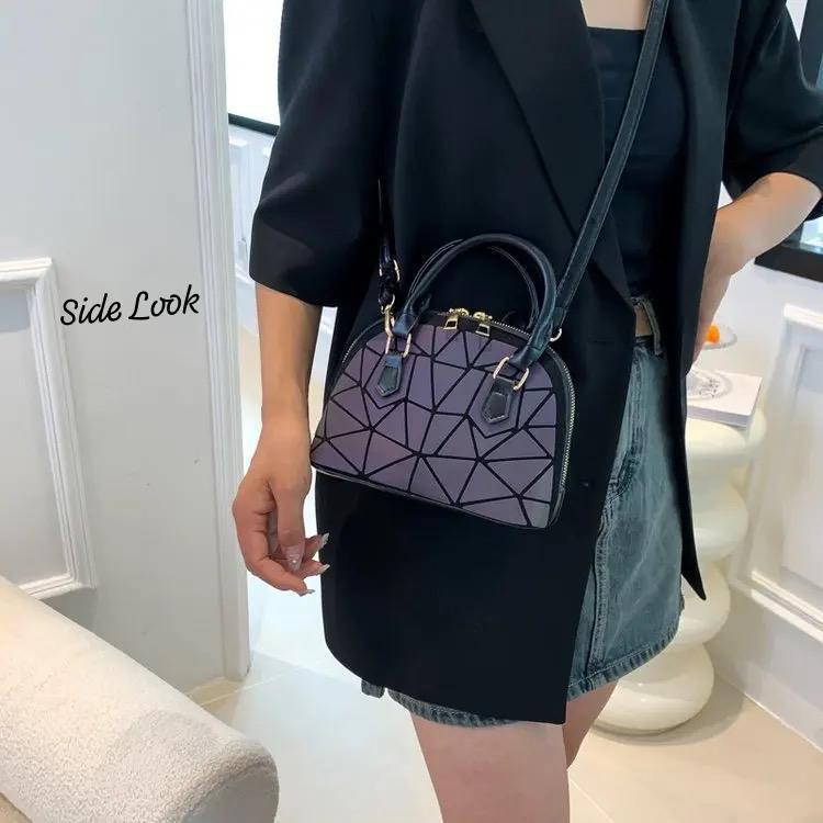 Woman wearing an iridescent geometric Bao Bao mini handbag crossbody with a blazer and skirt, showcasing its stylish side profile