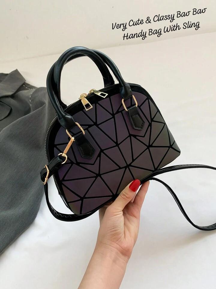 Hand holding an iridescent geometric Bao Bao mini handbag with a sling, emphasizing its compact size and unique pattern