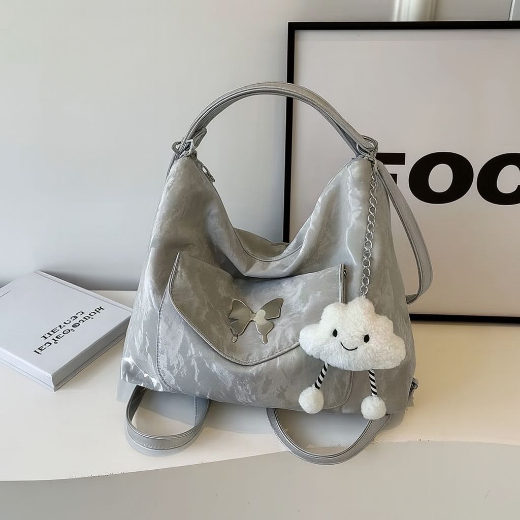 TRENDBUY grey metallic premium butterfly designer tote backpack with a cloud charm, presented on a minimalist surface.
