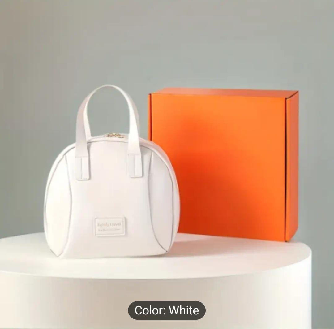 Single white large capacity travel makeup bag with a top handle, placed on a white pedestal next to an orange gift box.