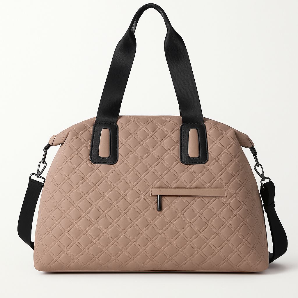 Front view of an elegant nude beige quilted duffle bag with black handles and a shoulder strap, featuring a subtle zippered pocket on a white background.